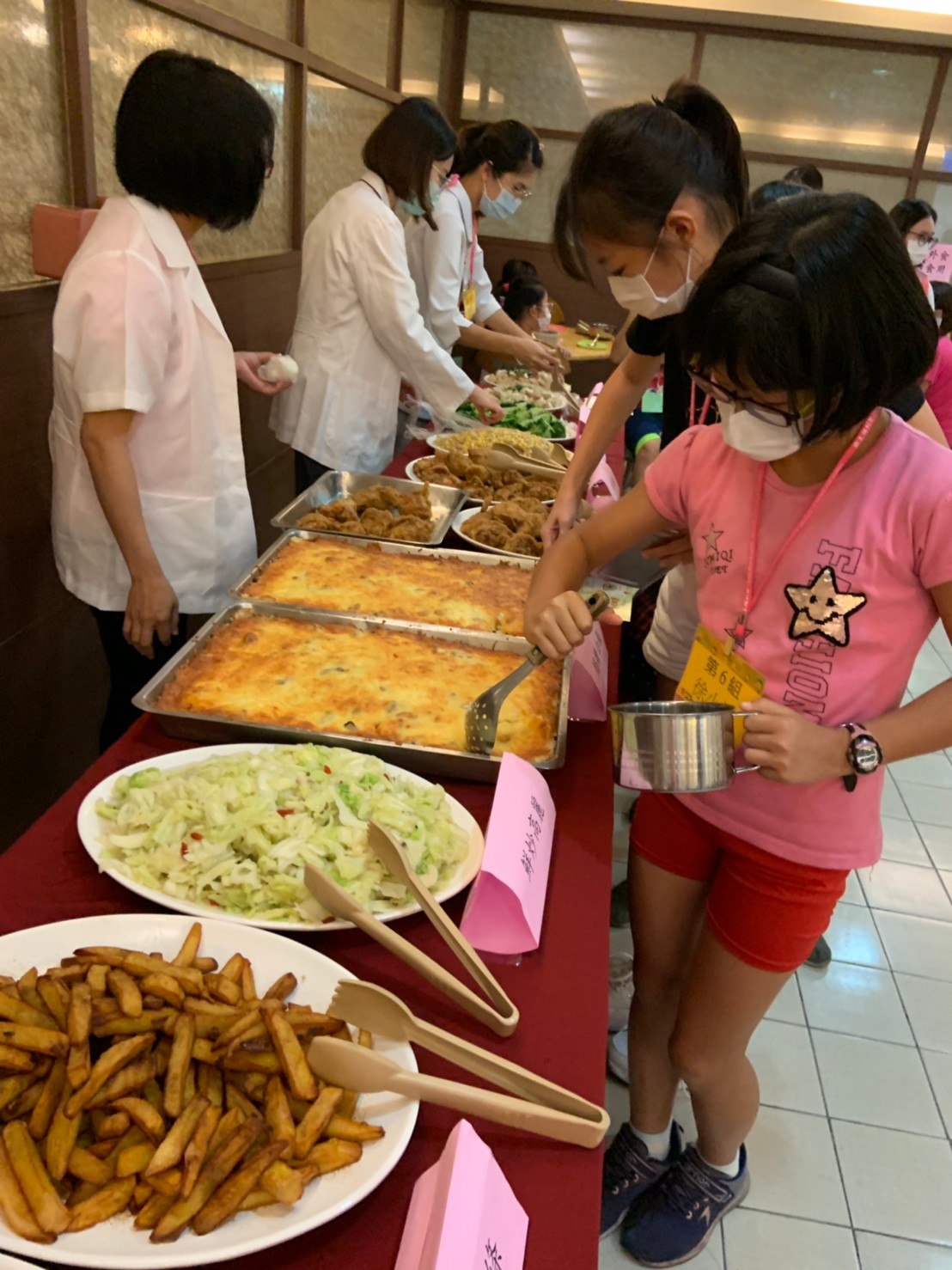 彰化醫院廚師團隊烹調美味午餐，學童現學現賣，完成最佳比例321打菜滿足營養所需。